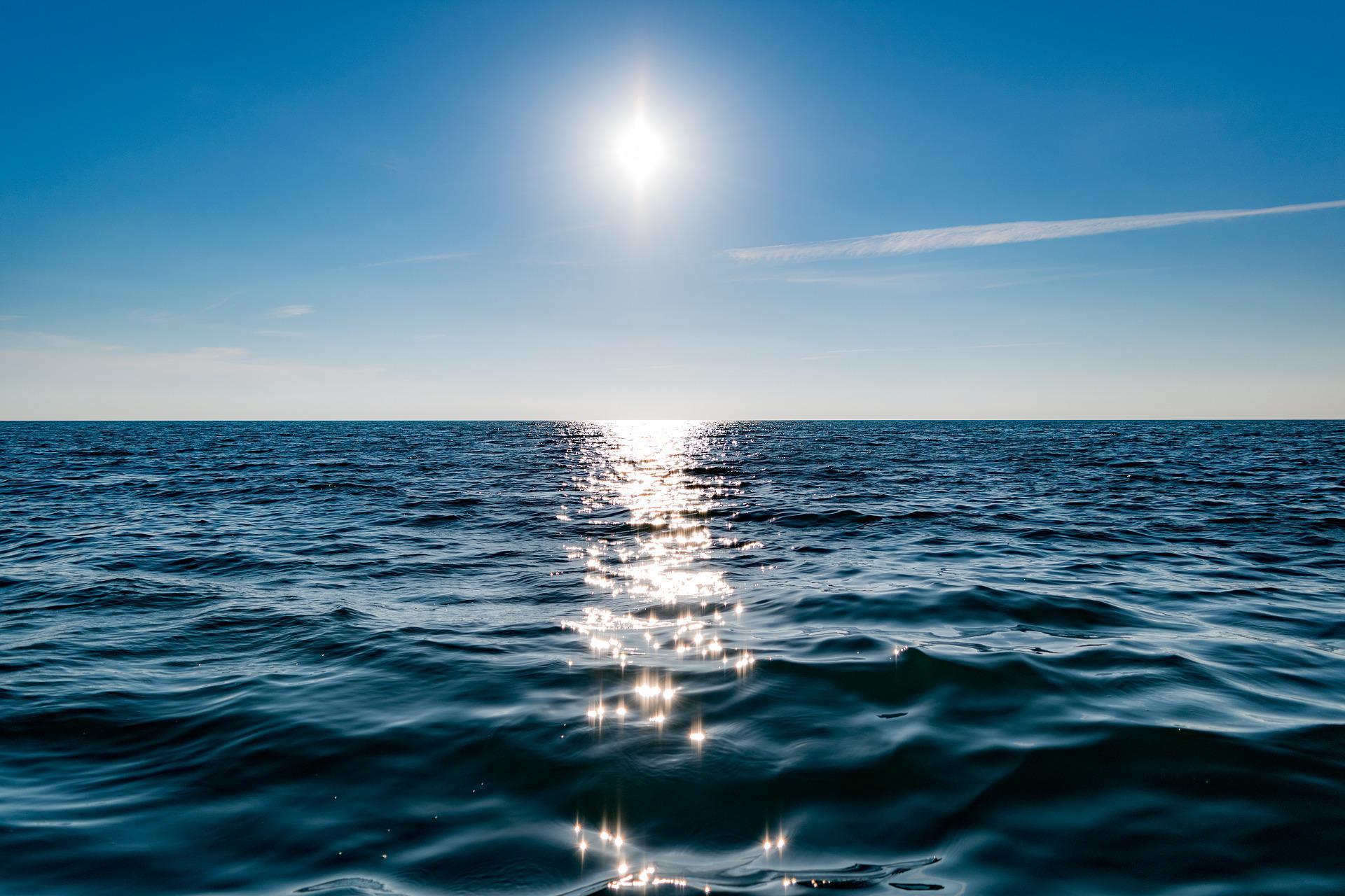 Am Horizont scheint über dem Meer die Sonne