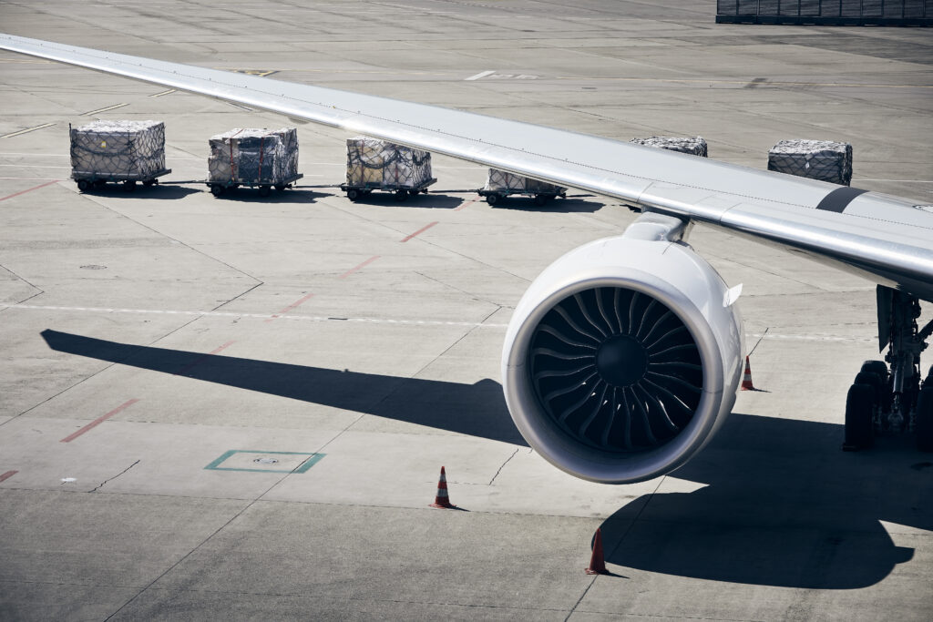 Flugzeugträger mit Turbine mit Fracht auf Wagen im Hintergrund