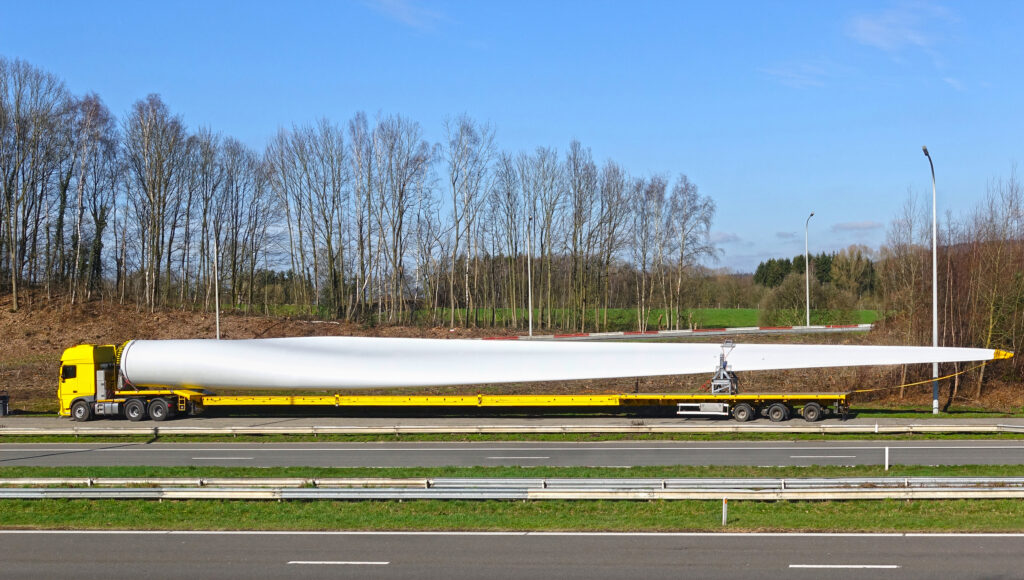 Fahrzeug transportiert langen Windradfluegel ueber die Autobahn