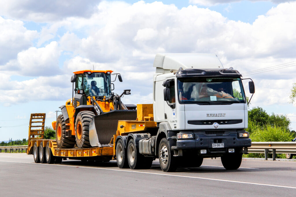 Bagger wird auf LKW ueber Strasse transportiert